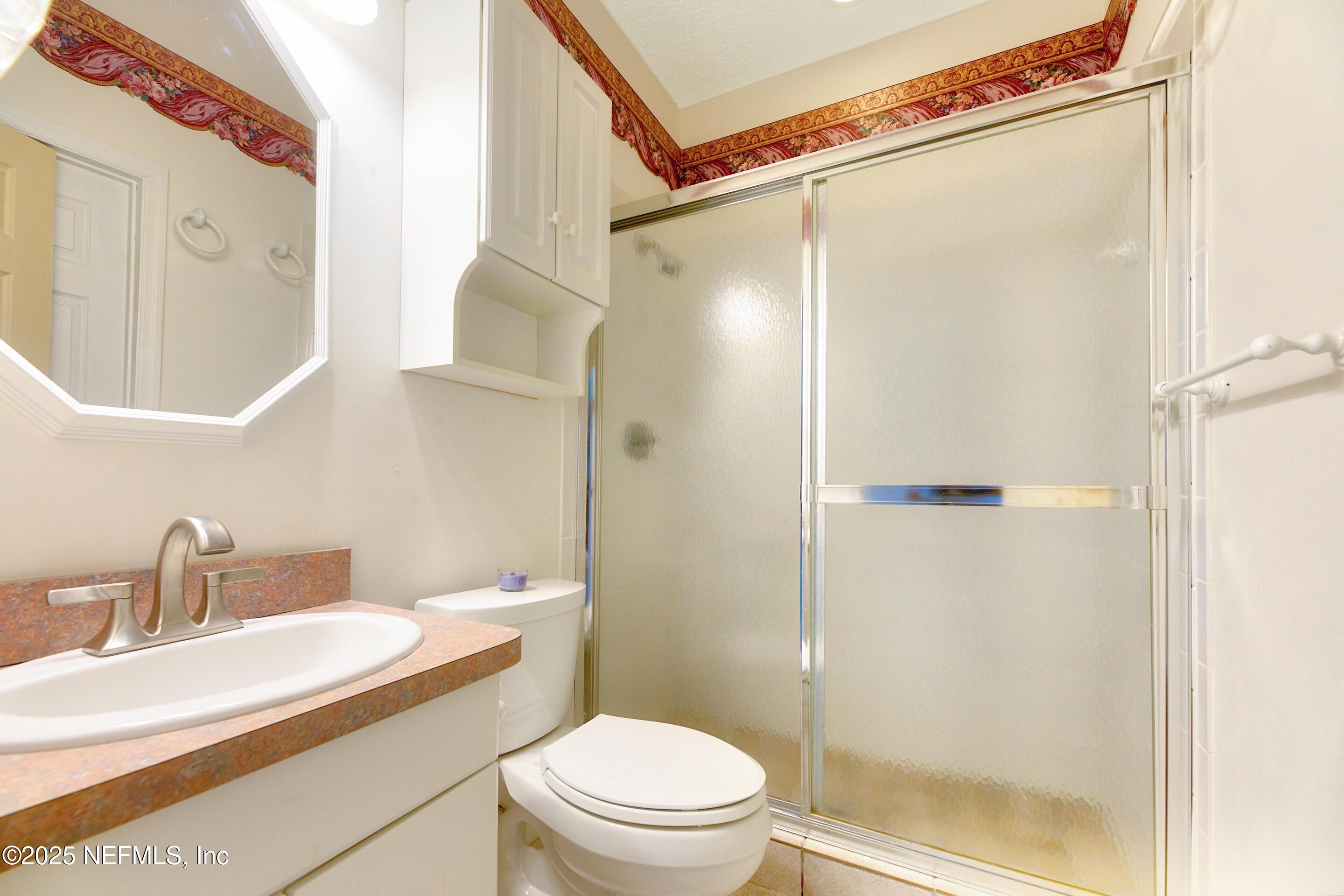 430 Marsh Point Circle St. Augustine, FL 32080 - Photo 38 of 69 a bathroom with a sink a mirror a toilet and shower