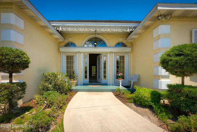 a view of a livingroom with a fireplace a ceiling fan and windows