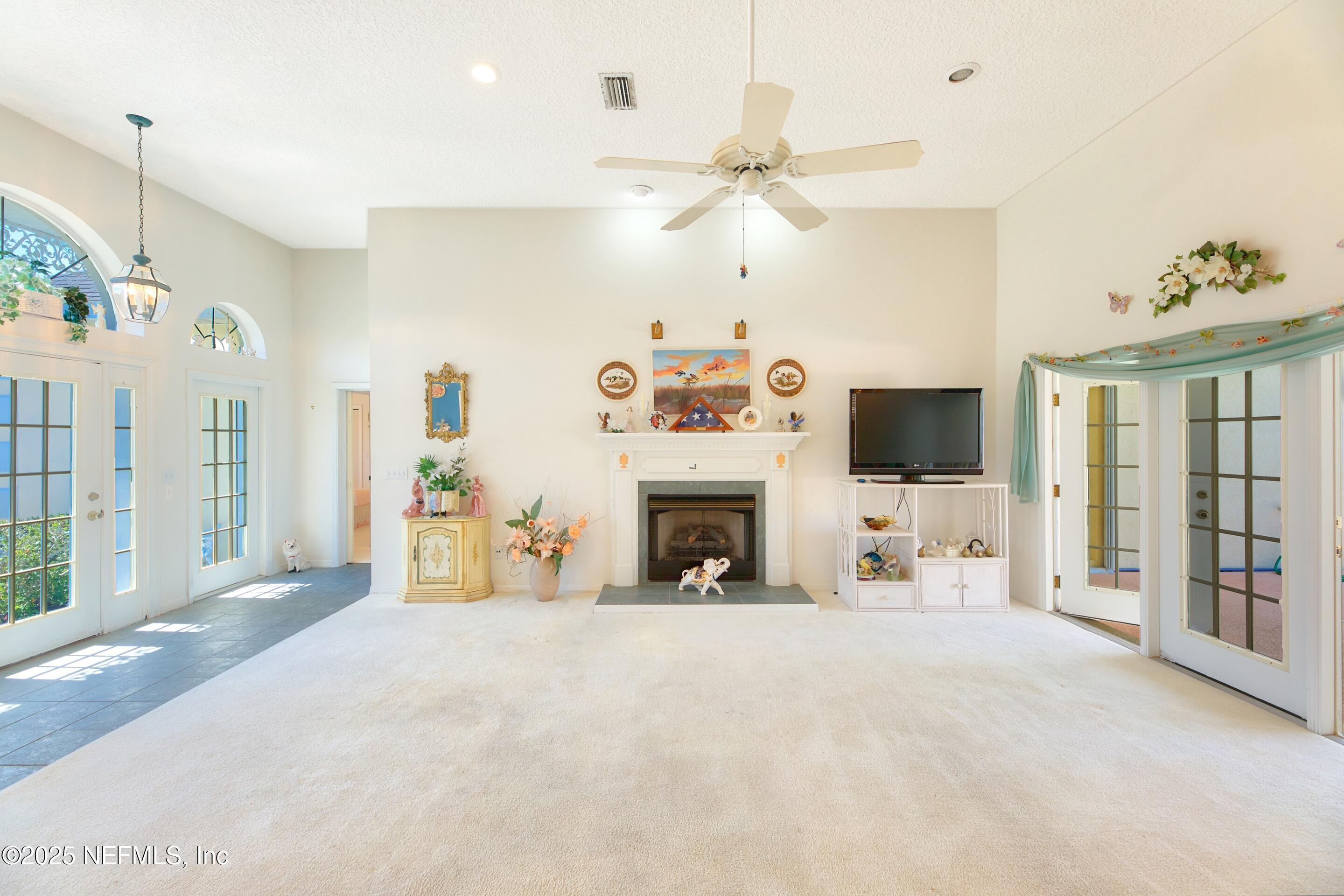 430 Marsh Point Circle St. Augustine, FL 32080 - Photo 10 of 69 a view of a livingroom with a fireplace a ceiling fan and windows