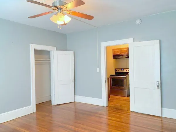 a view of a kitchen a ceiling fan and wooden floor
