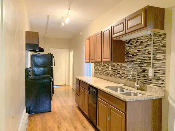 a kitchen with a sink cabinets and a wooden floor