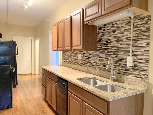 a kitchen with granite countertop a sink and a refrigerator