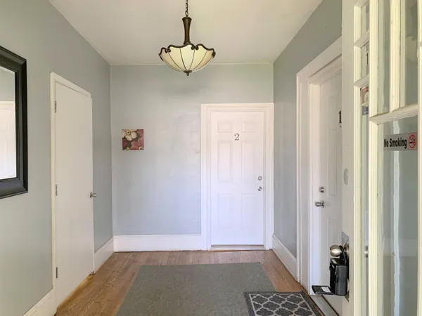 a view of a hallway with wooden floor and a livingroom
