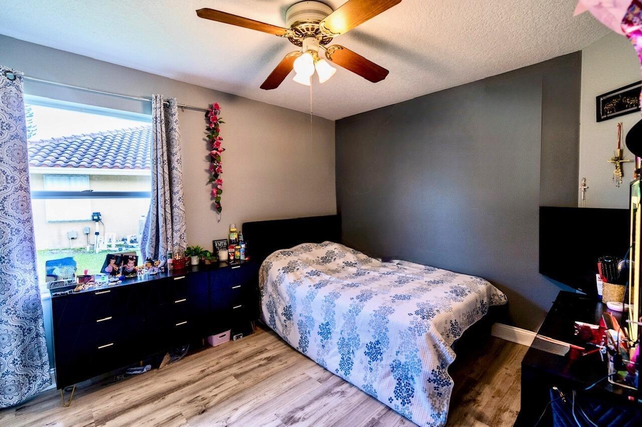 22392 Siesta Key Drive Boca Raton, FL 33428 - Photo 23 of 39 a bedroom with a bed and a chandelier