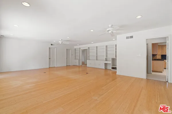 a view of an empty room with a window and a ceiling fan