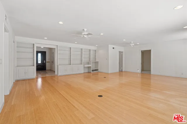 a view of an empty room with a window and a ceiling fan