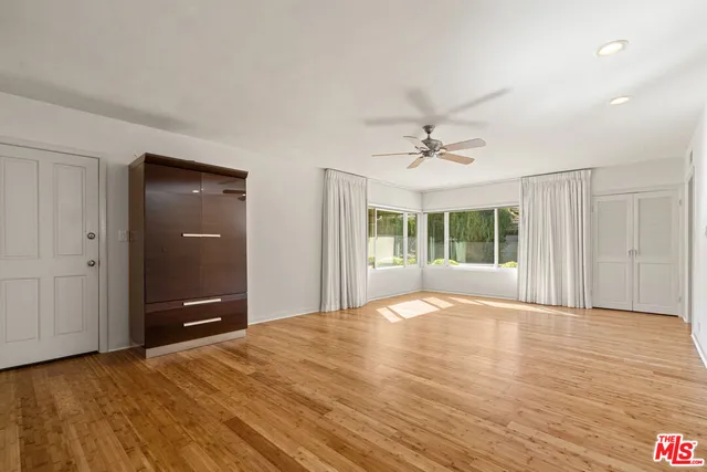 an empty room with windows and cabinet