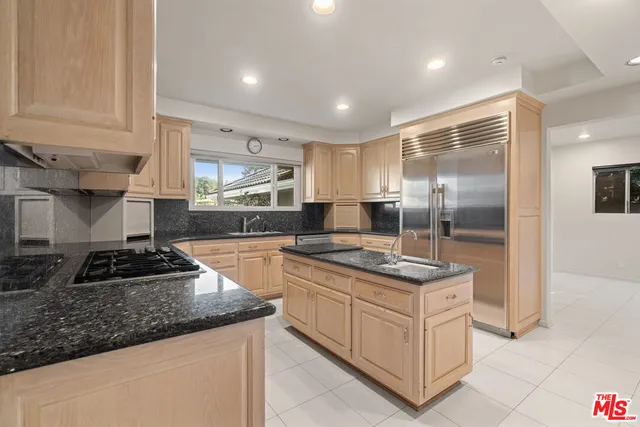 a kitchen with stainless steel appliances granite countertop a stove a sink and a refrigerator