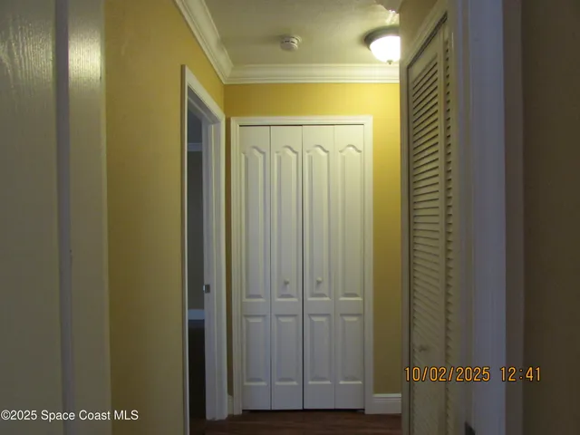 an empty room with wooden floor and fan