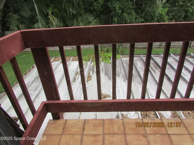 a view of an empty room with window and chandelier fan