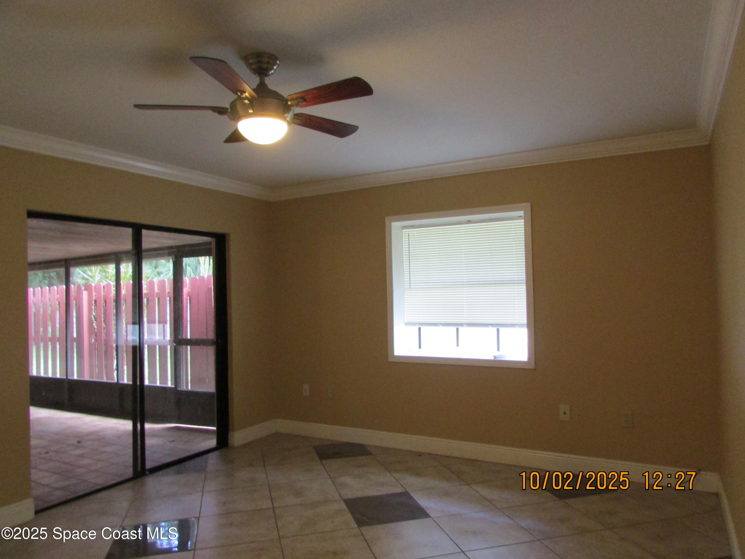 49 Piney Branch Way, Unit A Melbourne, FL 32904 - Photo 23 of 25 a view of an empty room with window and chandelier fan