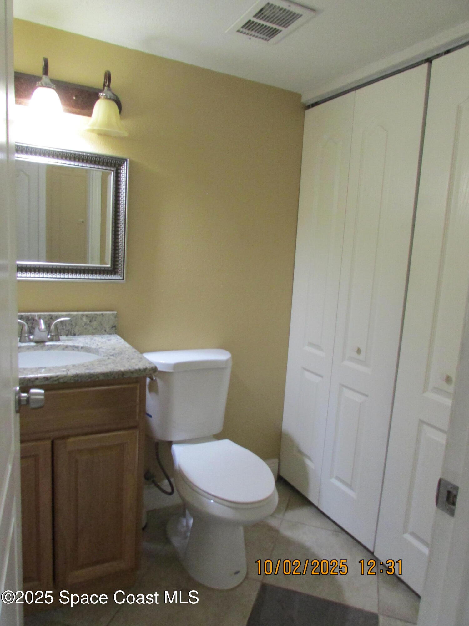 49 Piney Branch Way, Unit A Melbourne, FL 32904 - Photo 10 of 25 a bathroom with a toilet a sink and a mirror
