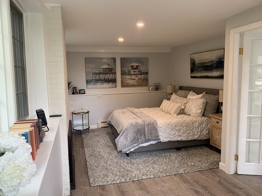 62 Pleasant Street Newton, MA 02459 - Photo 3 of 17 a spacious bedroom with a bed a table and large mirror in it