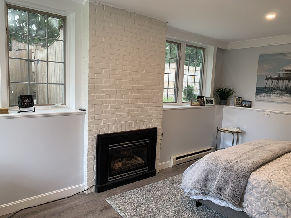 62 Pleasant Street Newton, MA 02459 - Photo 4 of 17 a bedroom with a bed a fireplace and windows