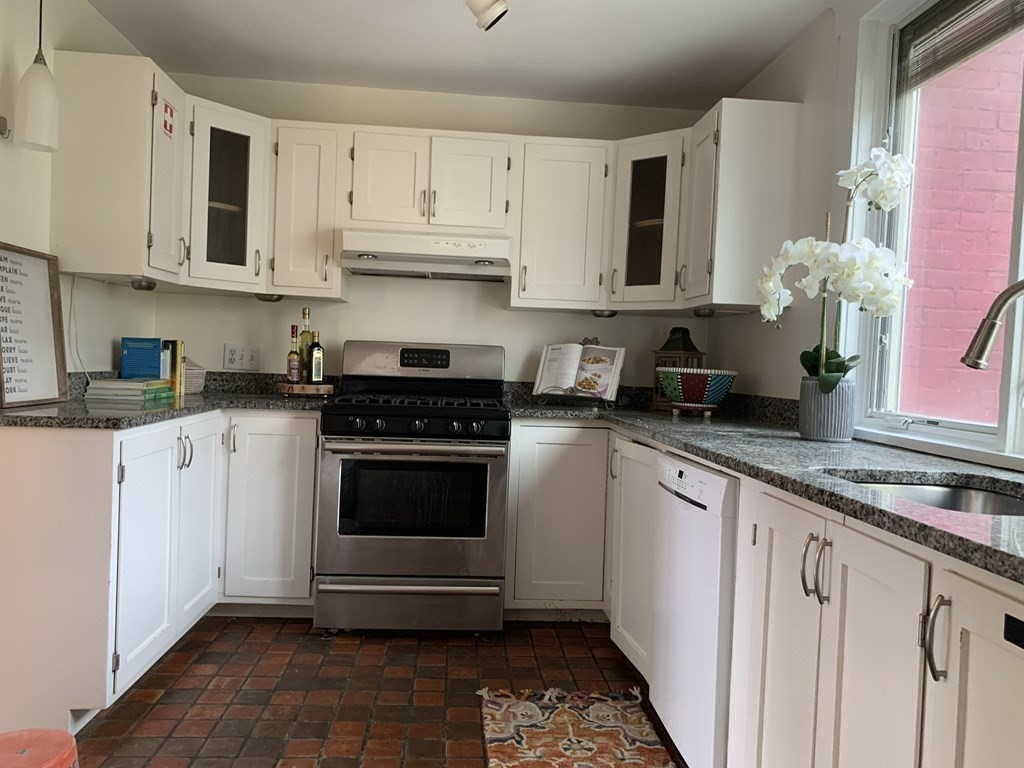62 Pleasant Street Newton, MA 02459 - Photo 10 of 17 a kitchen with stainless steel appliances granite countertop white cabinets sink and stove