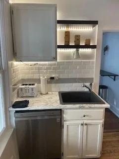 a kitchen with stainless steel appliances a stove a microwave and a hard wood floor