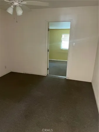 an empty room with a ceiling fan and a window