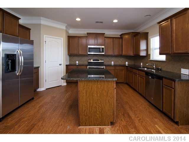 79369 Ridgehaven Road, Unit 26 Lancaster, SC 29720 - Photo 6 of 16 a kitchen with kitchen island granite countertop stainless steel appliances and wooden cabinets