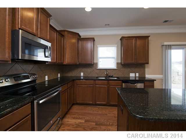 79369 Ridgehaven Road, Unit 26 Lancaster, SC 29720 - Photo 7 of 16 a kitchen with stainless steel appliances granite countertop a stove a sink and a microwave