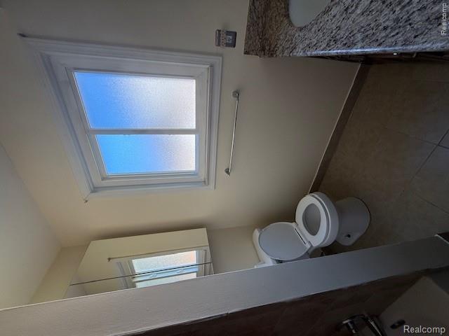 43038 Hanford Road Canton, MI 48187 - Photo 27 of 36 Bathroom featuring a frosted window, tile flooring, wall-mounted medicine cabinet, white toilet, and a vanity with a granite countertop and integrated sink
