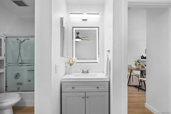 a bathroom with a granite countertop sink toilet and shower