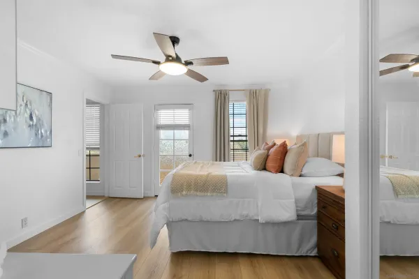 a bedroom with a large bed and wooden floor