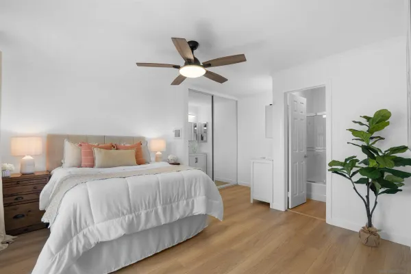 a bedroom with a bed and a potted plant