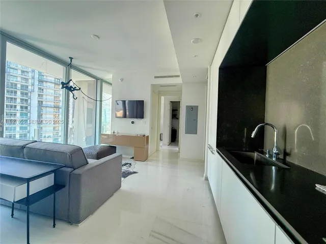 a living room with furniture a large window and wooden floor