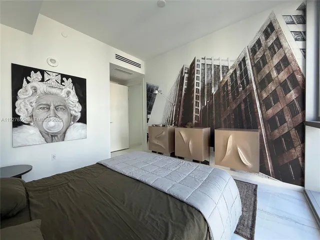 a bedroom with a bed and a painting on the wall