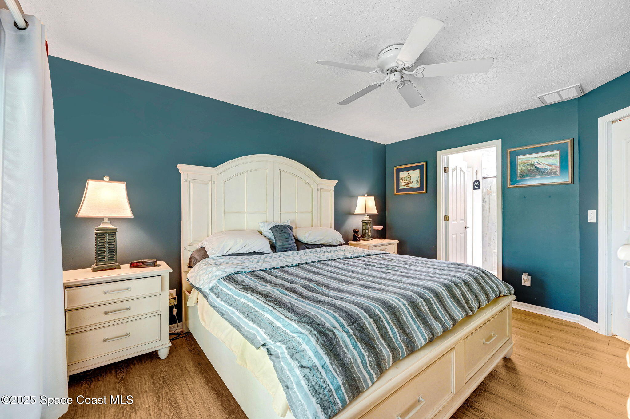 1507 Meadowbrook Road Northeast Palm Bay, FL 32905 - Photo 10 of 50 a bedroom with a bed and a chandelier