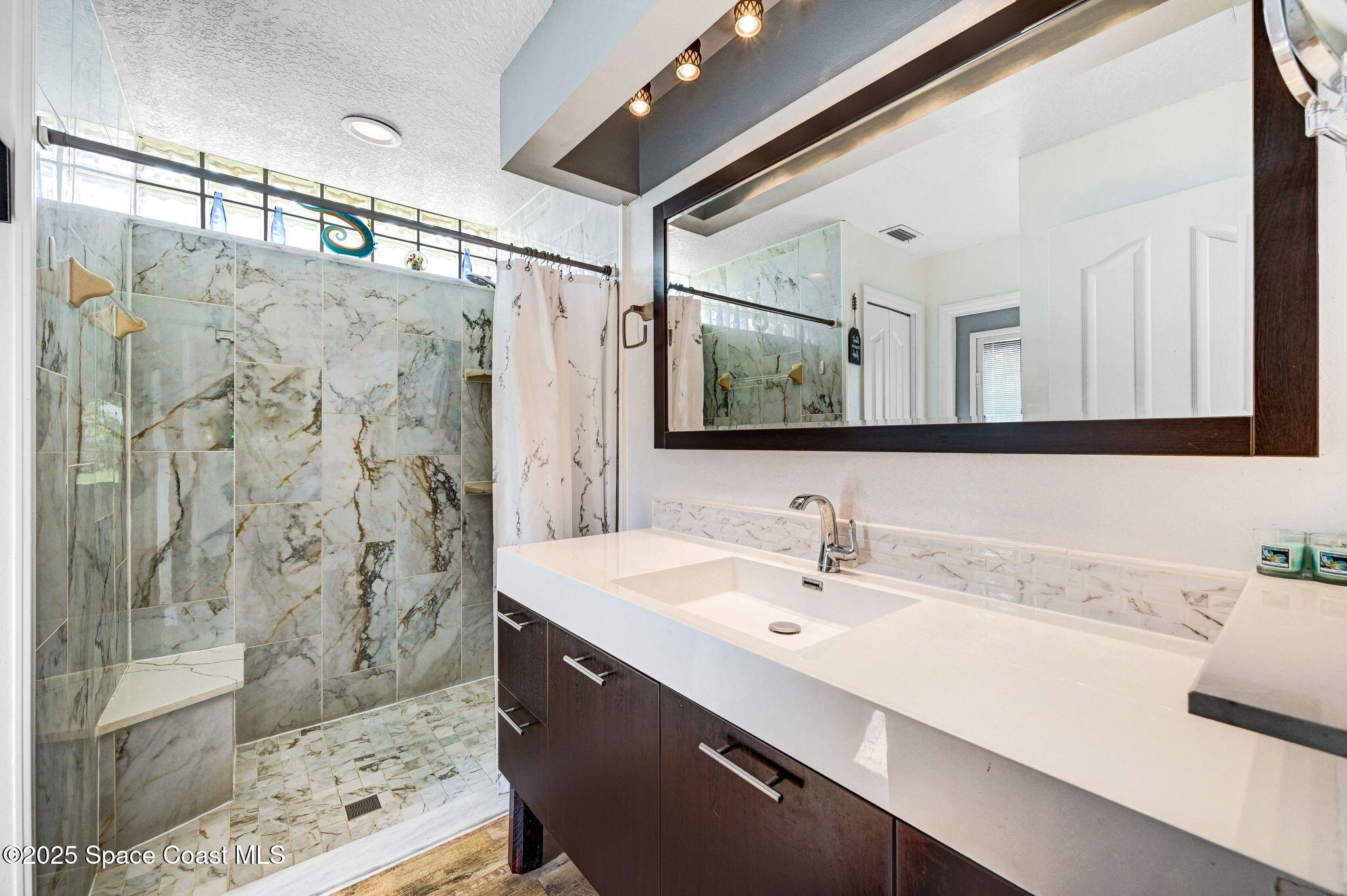 1507 Meadowbrook Road Northeast Palm Bay, FL 32905 - Photo 12 of 50 a bathroom with a double vanity sink mirror and shower