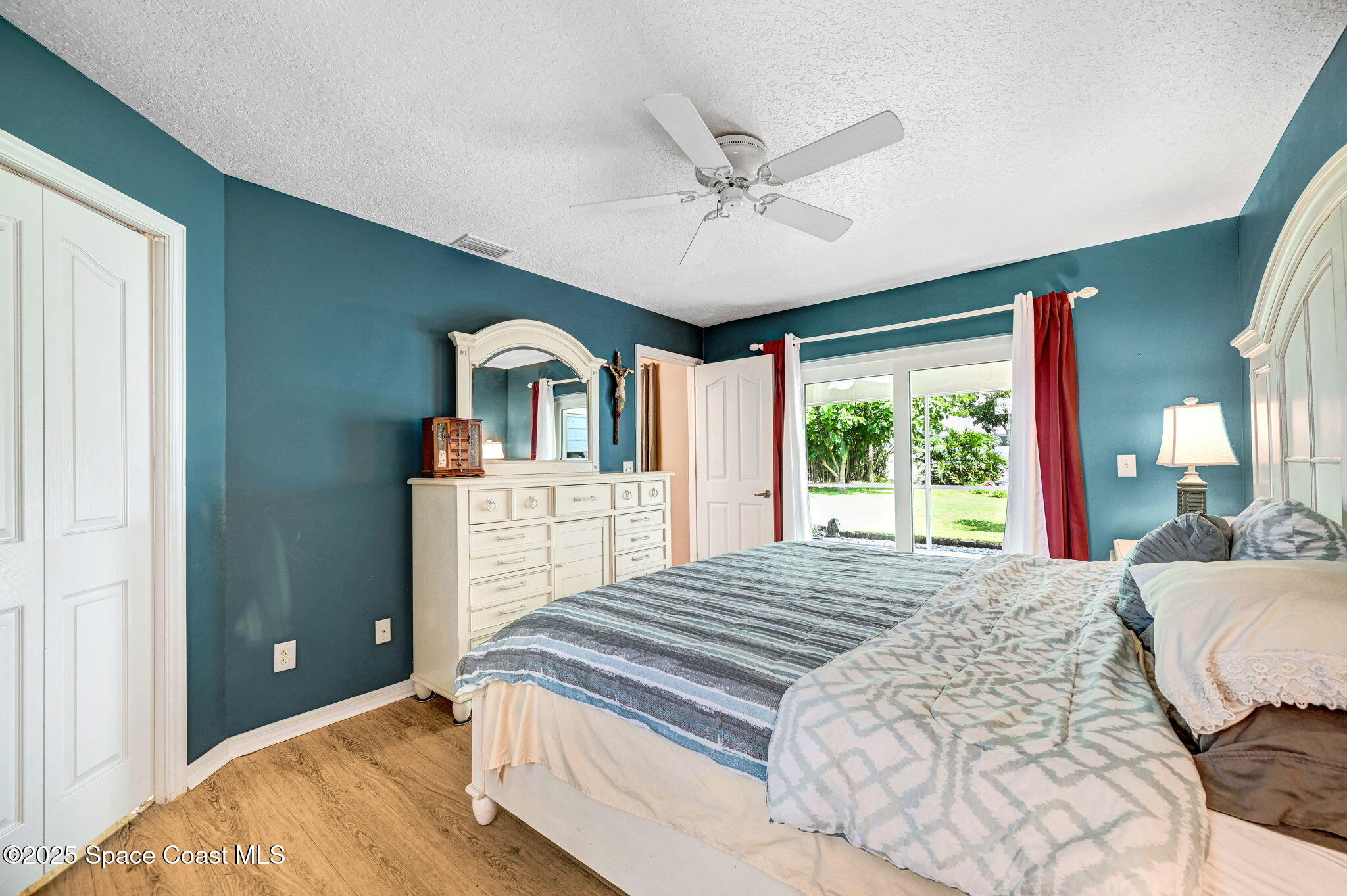 1507 Meadowbrook Road Northeast Palm Bay, FL 32905 - Photo 14 of 50 a spacious bedroom with a large bed and a chandelier