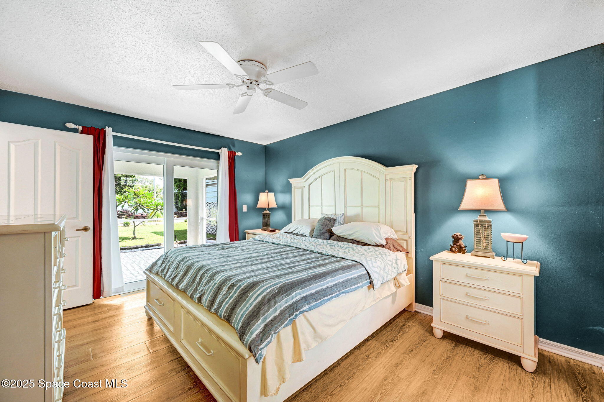 1507 Meadowbrook Road Northeast Palm Bay, FL 32905 - Photo 16 of 50 a bedroom with a large bed wooden floor and window