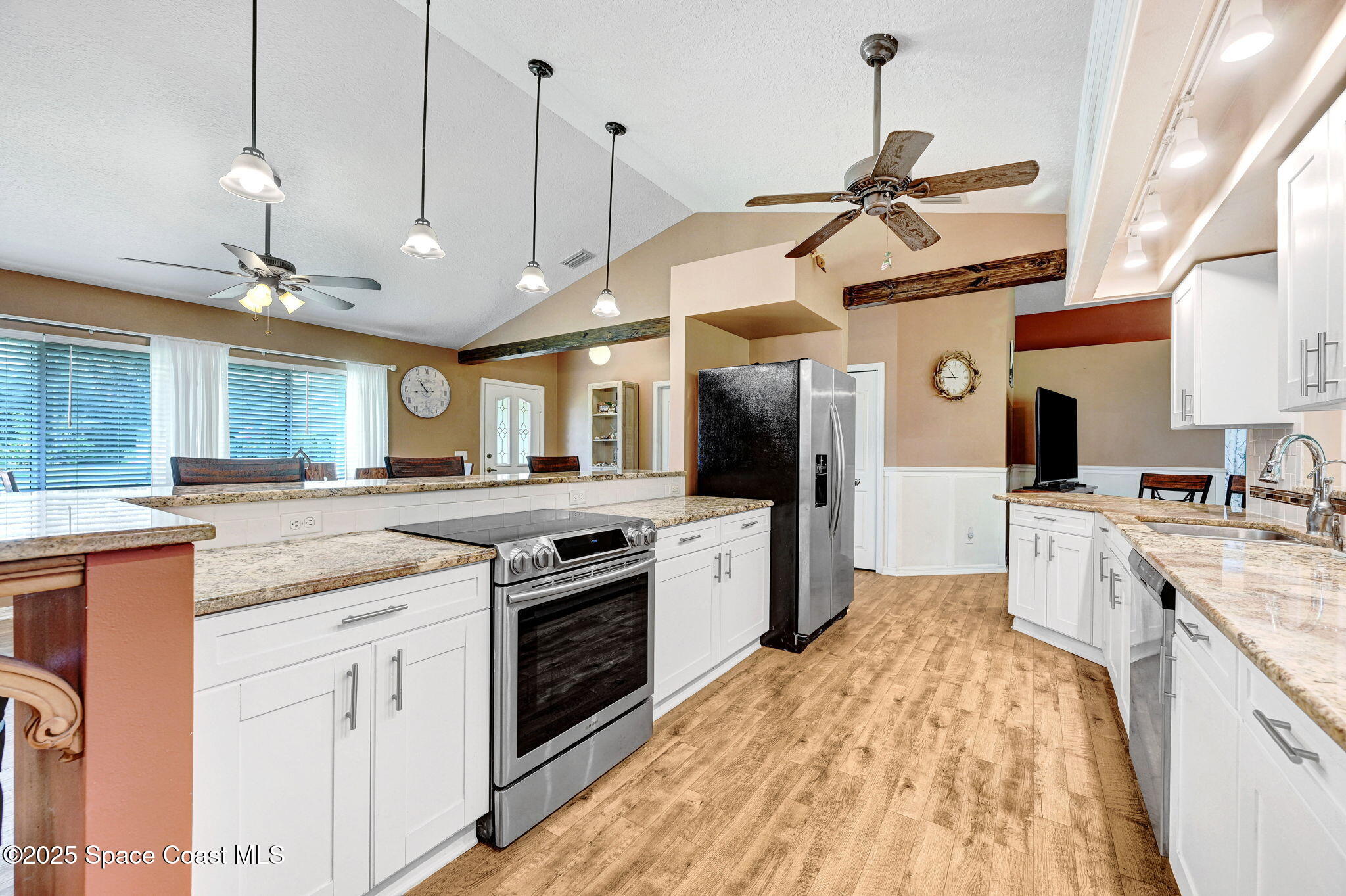 1507 Meadowbrook Road Northeast Palm Bay, FL 32905 - Photo 18 of 50 a kitchen with stainless steel appliances granite countertop a sink a stove and a wooden floors