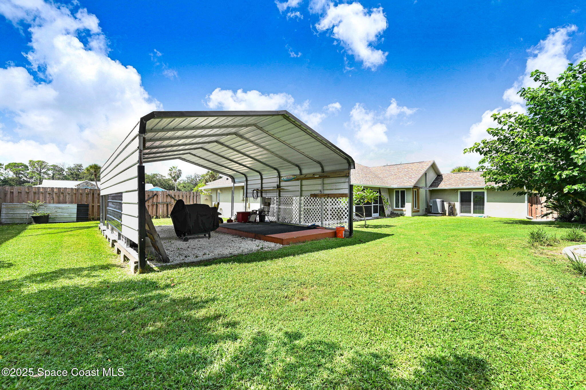 1507 Meadowbrook Road Northeast Palm Bay, FL 32905 - Photo 34 of 50 a view of a house with a backyard porch and sitting area
