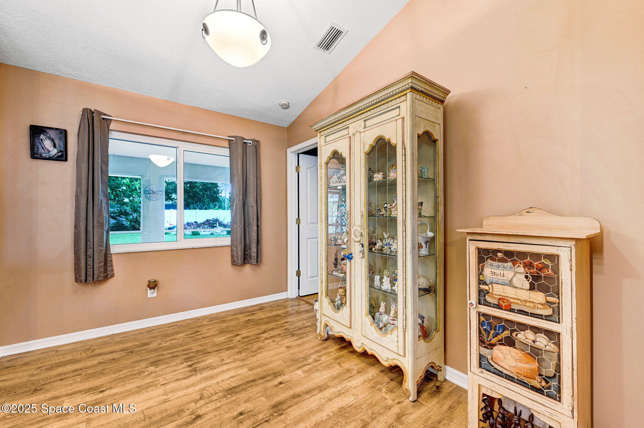 1507 Meadowbrook Road Northeast Palm Bay, FL 32905 - Photo 9 of 50 a view of an empty room with wooden floor and a window