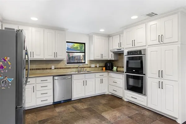 a kitchen with stainless steel appliances granite countertop a refrigerator sink and cabinets