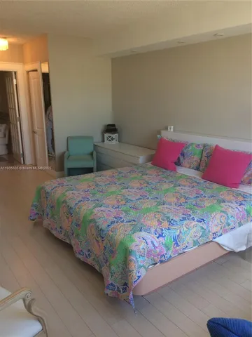 a bed sitting in a bedroom and a wooden floor