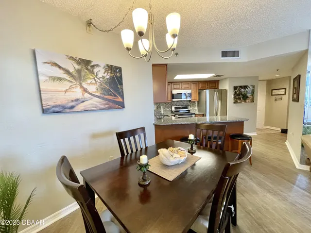 a kitchen with granite countertop a refrigerator stove and sink