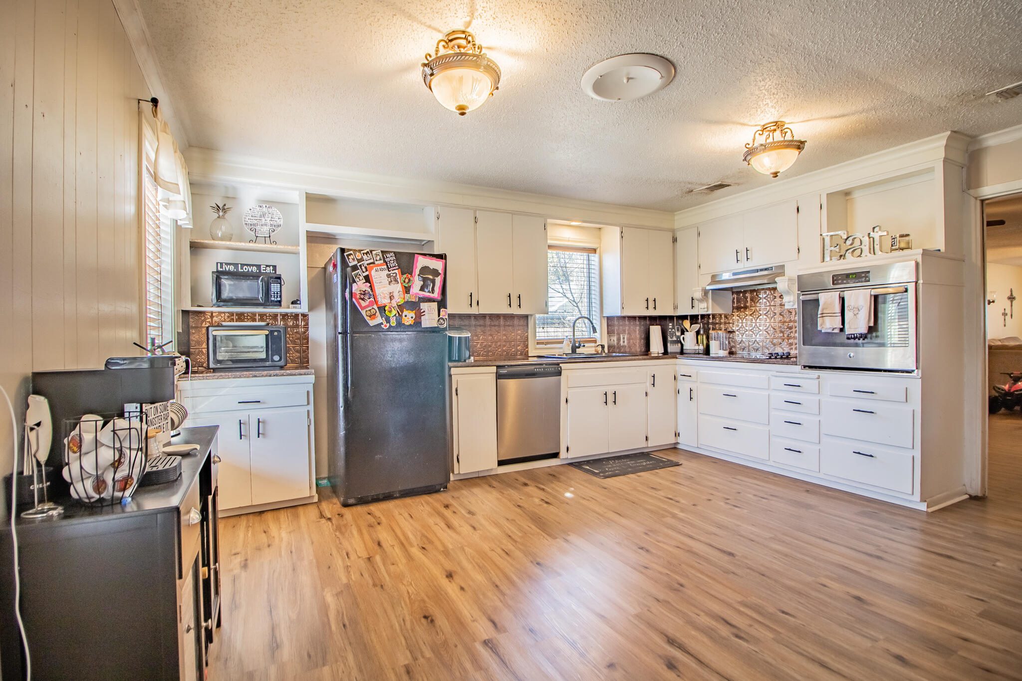 907 Ave H Hale Center, TX 79041 - Photo 11 of 32 a kitchen with stainless steel appliances granite countertop a refrigerator stove top oven and sink with wooden floor