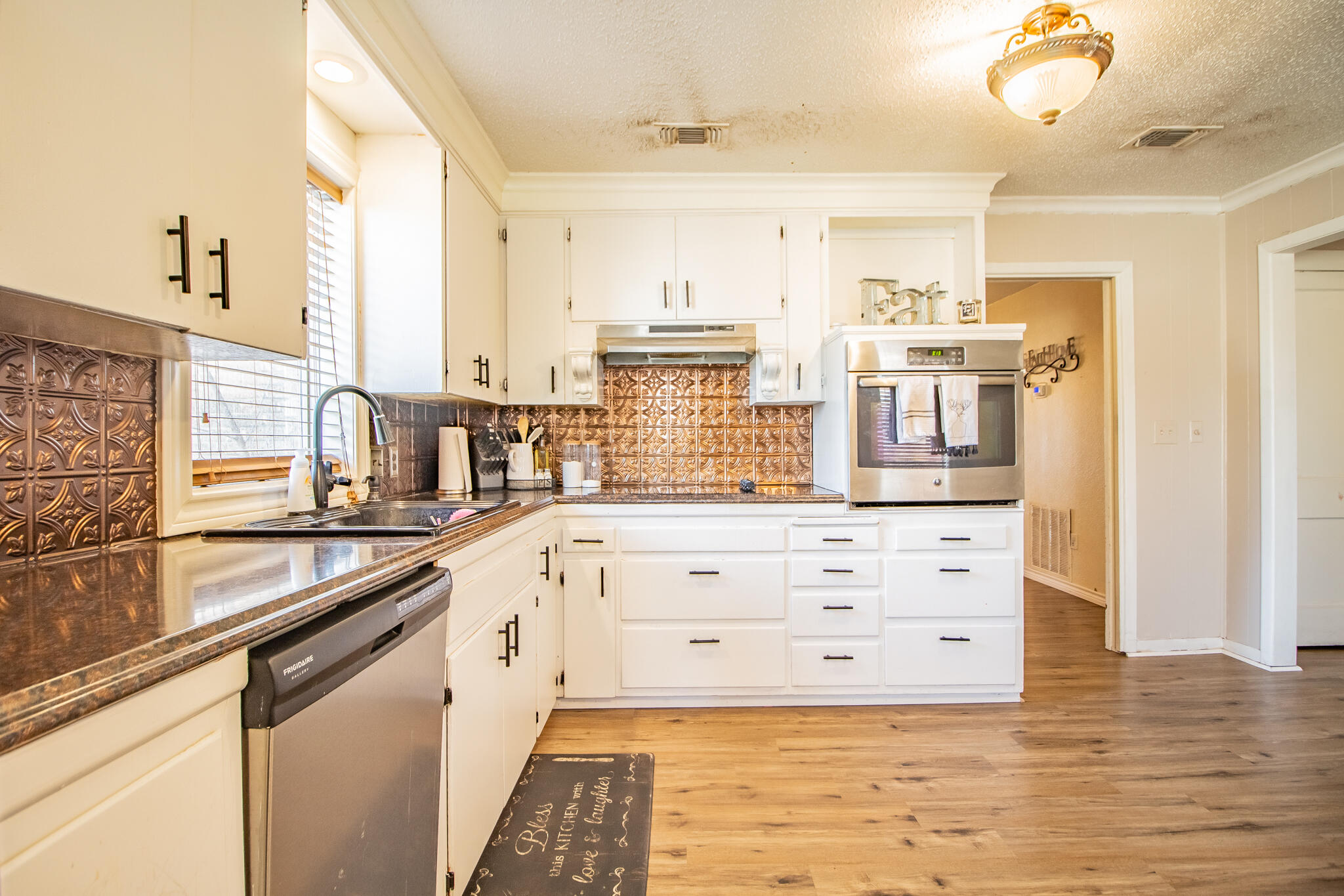 907 Ave H Hale Center, TX 79041 - Photo 13 of 32 a kitchen with granite countertop white cabinets and white appliances
