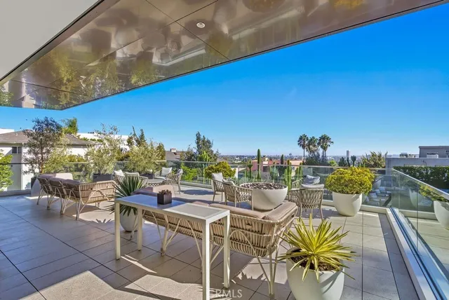 a view of a patio with couches table and chairs and potted plants