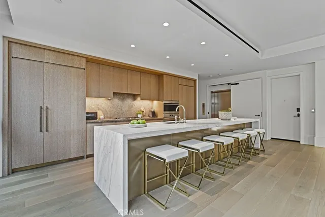 a kitchen with stainless steel appliances granite countertop a table chairs sink and cabinets