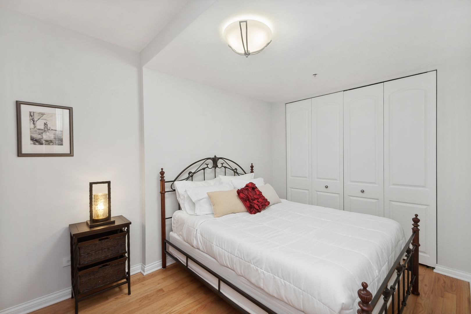 21 West Chestnut Street, Unit 1408 Chicago, IL 60610 - Photo 12 of 17 a bedroom with a bed and wooden floor