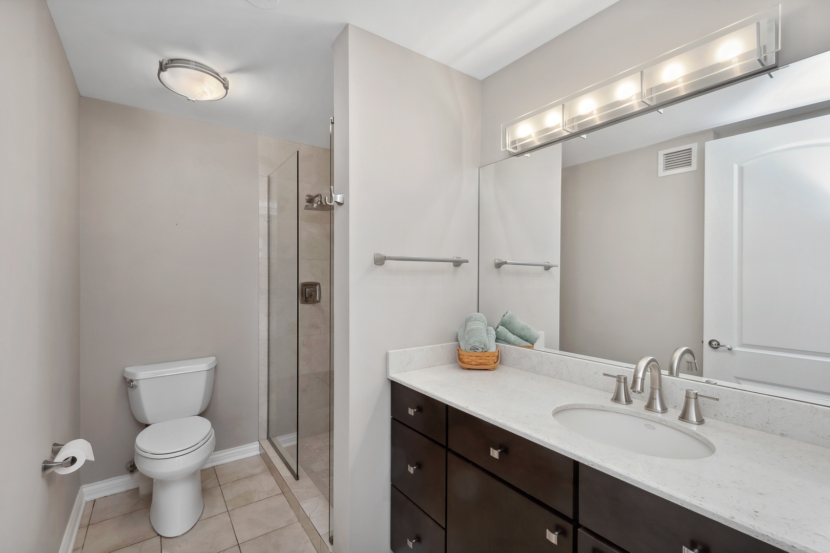 21 West Chestnut Street, Unit 1408 Chicago, IL 60610 - Photo 13 of 17 a bathroom with a toilet a sink a mirror and vanity