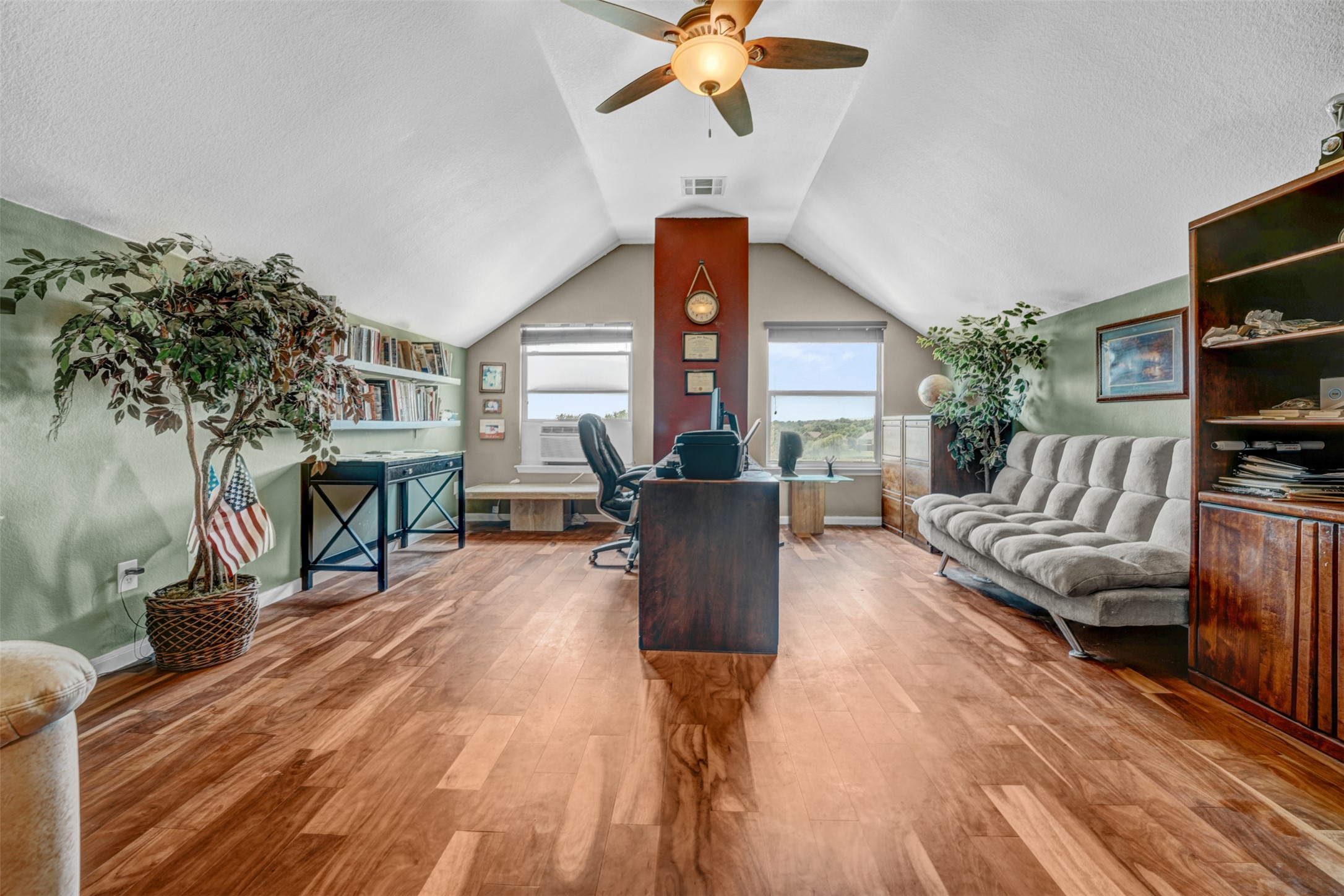 2521 Amen Corner Road Pflugerville, TX 78660 - Photo 23 of 40 Vaulted ceiling with a ceiling fan, wood-finish flooring, built-in shelving, and two windows providing natural light