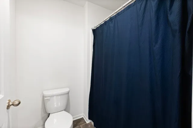a white toilet sitting next to a wooden cabinet