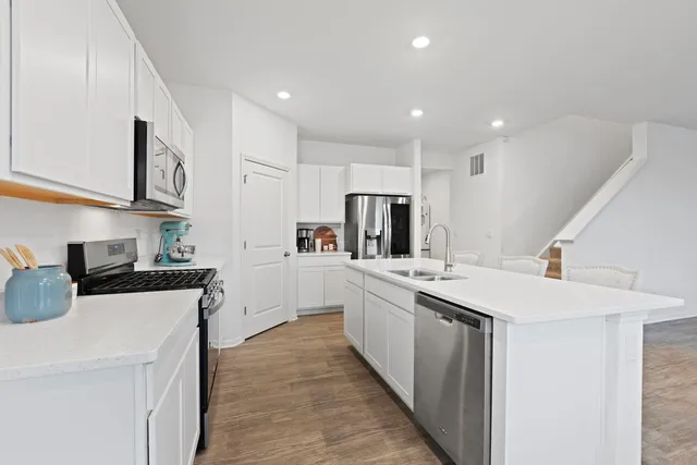 a kitchen with stainless steel appliances a sink stove and refrigerator