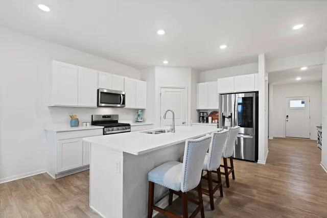 a kitchen with white cabinets and stainless steel appliances