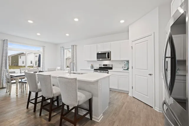 a kitchen with white cabinets and stainless steel appliances